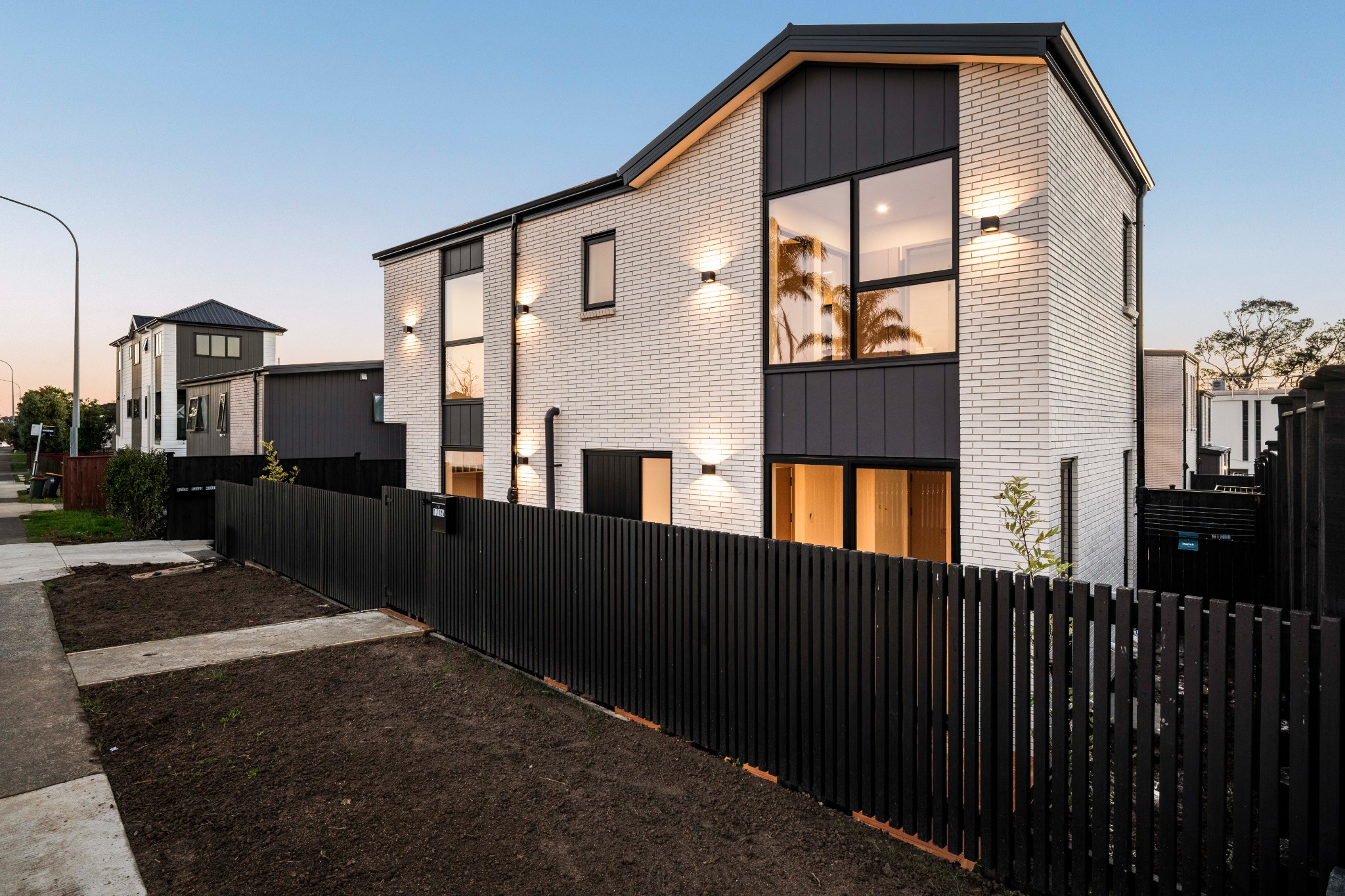 Warm exterior lighting and strong gabled form